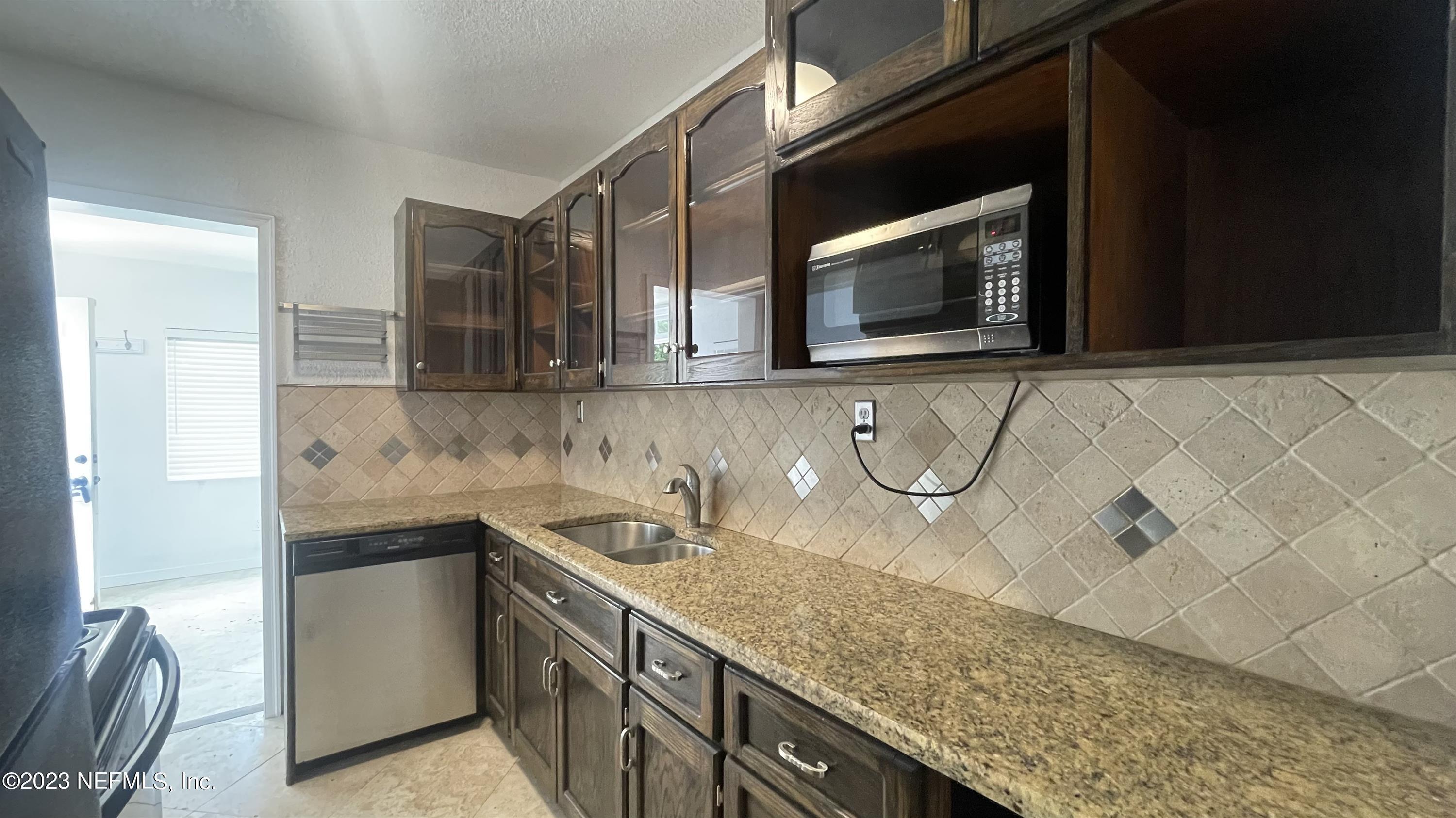 5228 Sunderland Road Jacksonville, FL 32210 - Photo 9 of 18 a kitchen with stainless steel appliances granite countertop a sink and a microwave