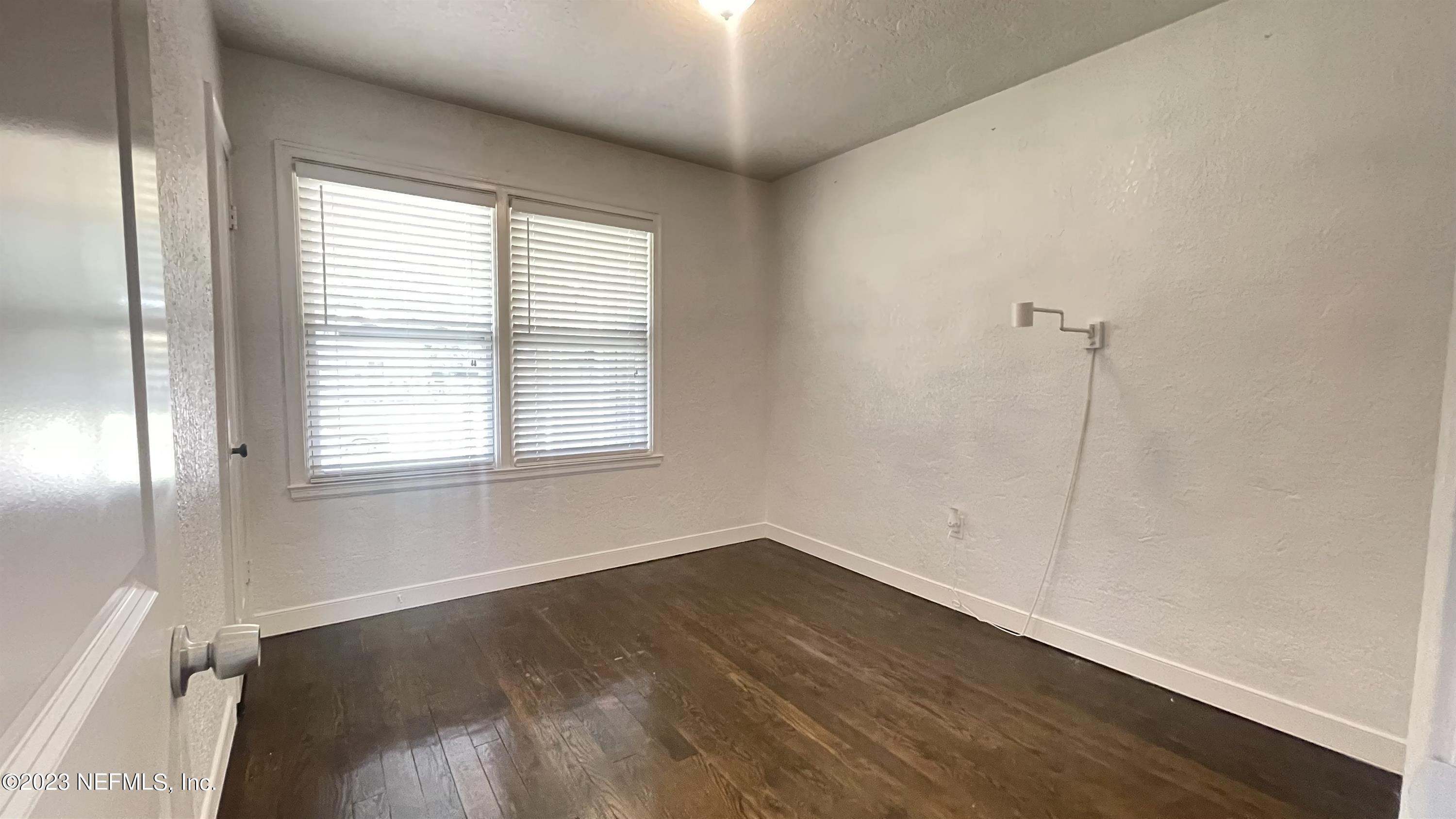 5228 Sunderland Road Jacksonville, FL 32210 - Photo 10 of 18 an empty room with wooden floor and windows