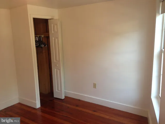 a view of a room with wooden floor and a window