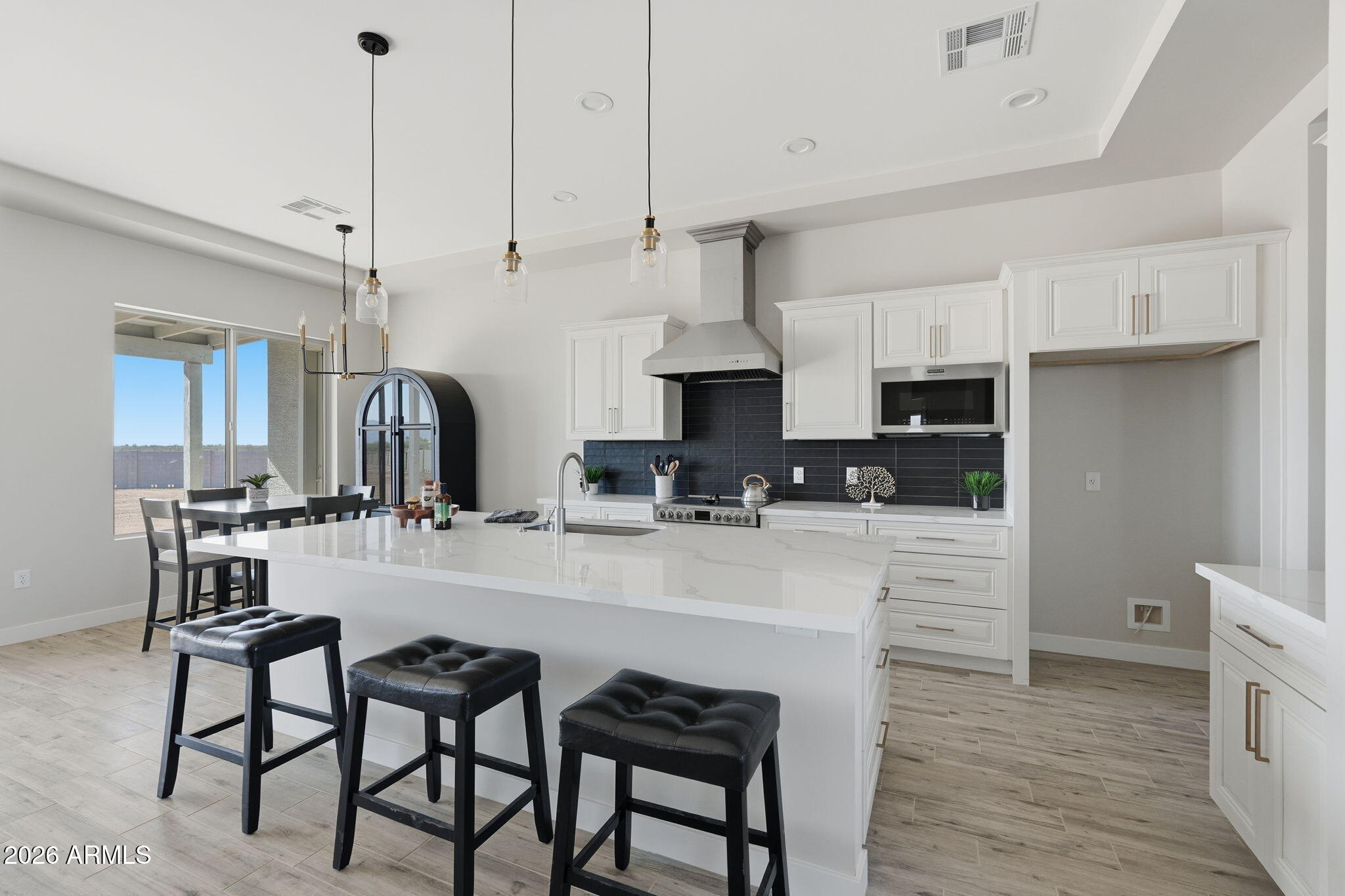 23131 West Skinner Road Wittmann, AZ 85361 - Photo 24 of 48 a kitchen with stainless steel appliances kitchen island granite countertop a table chairs sink and cabinets