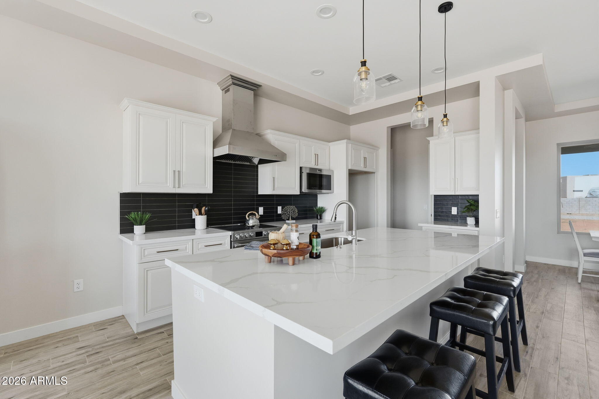 23131 West Skinner Road Wittmann, AZ 85361 - Photo 25 of 48 a kitchen with stainless steel appliances a stove a sink a microwave a dining table and chairs