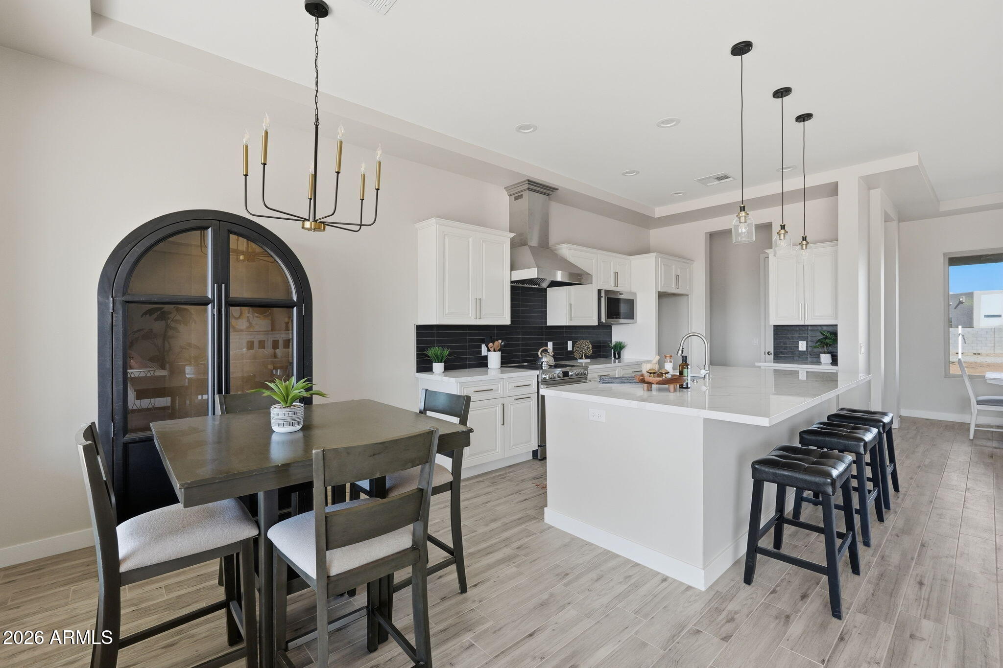 23131 West Skinner Road Wittmann, AZ 85361 - Photo 26 of 48 a kitchen with stainless steel appliances a dining table chairs and white cabinets