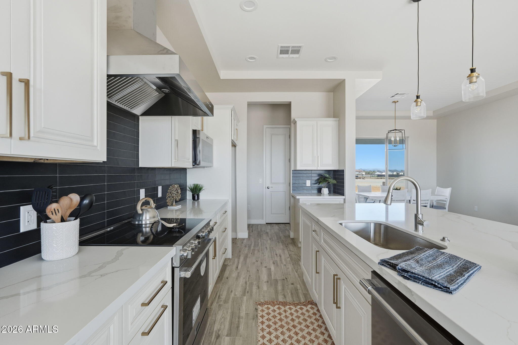 23131 West Skinner Road Wittmann, AZ 85361 - Photo 27 of 48 a kitchen with stainless steel appliances granite countertop a sink stove and refrigerator
