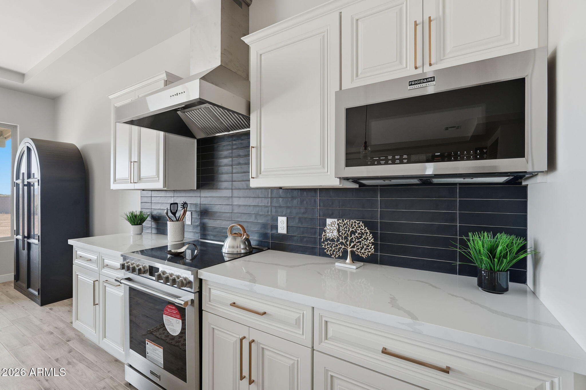 23131 West Skinner Road Wittmann, AZ 85361 - Photo 30 of 48 a kitchen with stainless steel appliances a stove a microwave a sink a refrigerator and cabinets