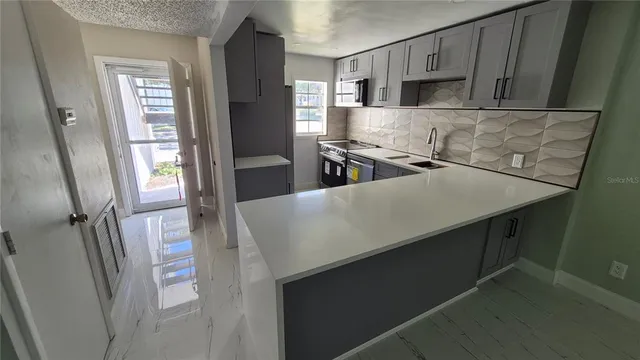 a kitchen with stainless steel appliances a refrigerator and a stove