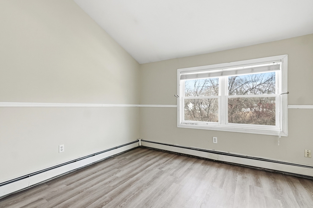 6 Adams Court, Unit 6 Amesbury, MA 01913 - Photo 14 of 22 an empty room with wooden floor and window