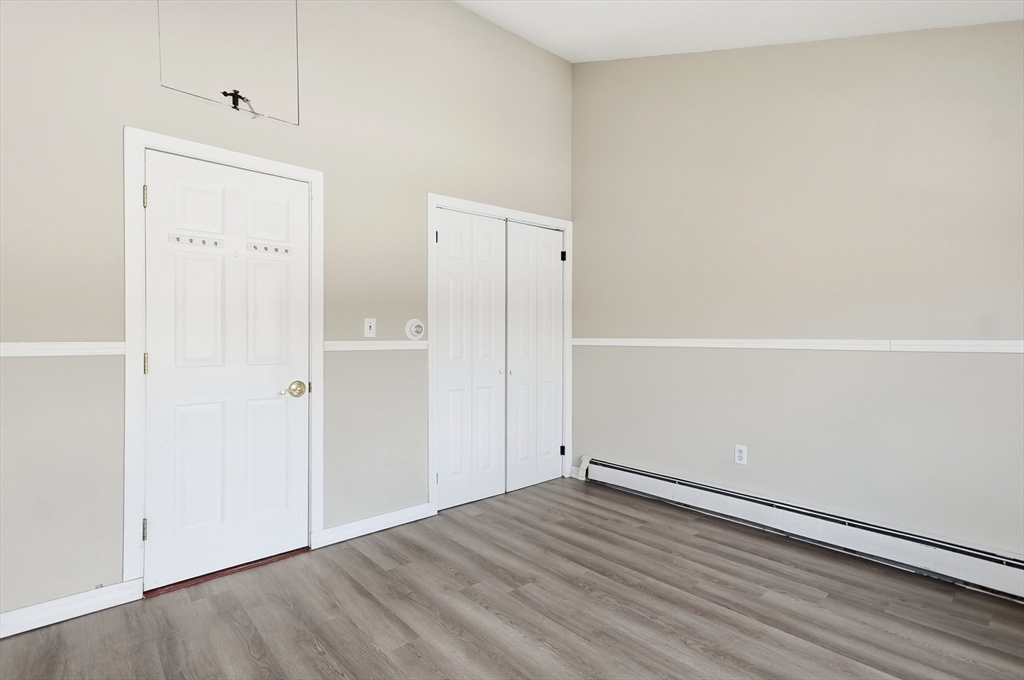6 Adams Court, Unit 6 Amesbury, MA 01913 - Photo 15 of 22 an empty room with wooden floor