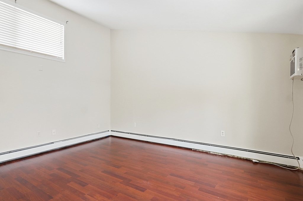 6 Adams Court, Unit 6 Amesbury, MA 01913 - Photo 17 of 22 a view of an empty room with wooden floor and a window
