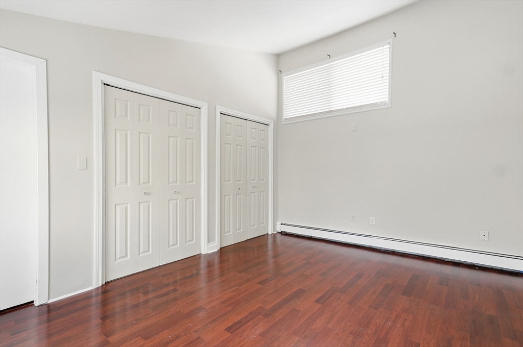 6 Adams Court, Unit 6 Amesbury, MA 01913 - Photo 18 of 22 an empty room with wooden floor and windows