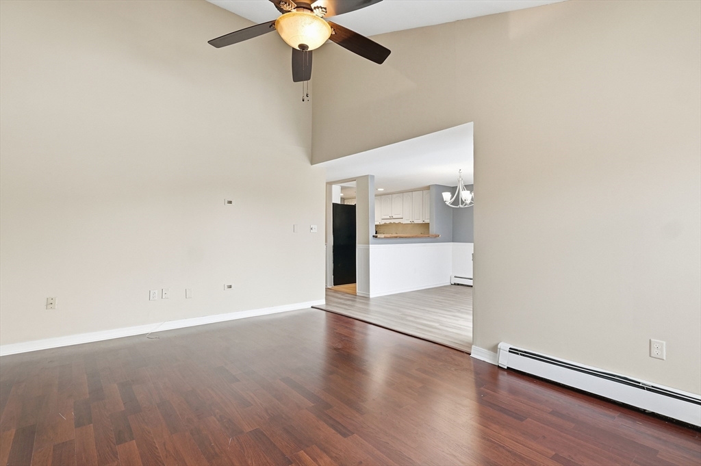 6 Adams Court, Unit 6 Amesbury, MA 01913 - Photo 4 of 22 an empty room with wooden floor fan and windows