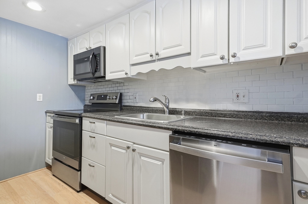 6 Adams Court, Unit 6 Amesbury, MA 01913 - Photo 7 of 22 a kitchen with stainless steel appliances granite countertop a sink a stove and microwave