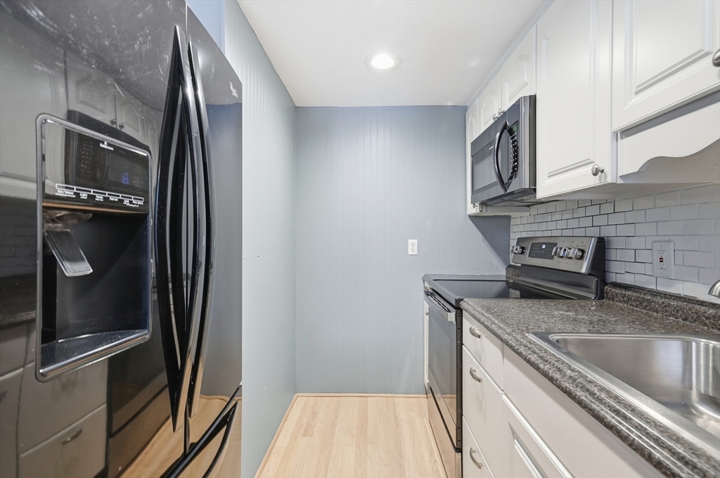6 Adams Court, Unit 6 Amesbury, MA 01913 - Photo 8 of 22 a kitchen with granite countertop a refrigerator and a sink