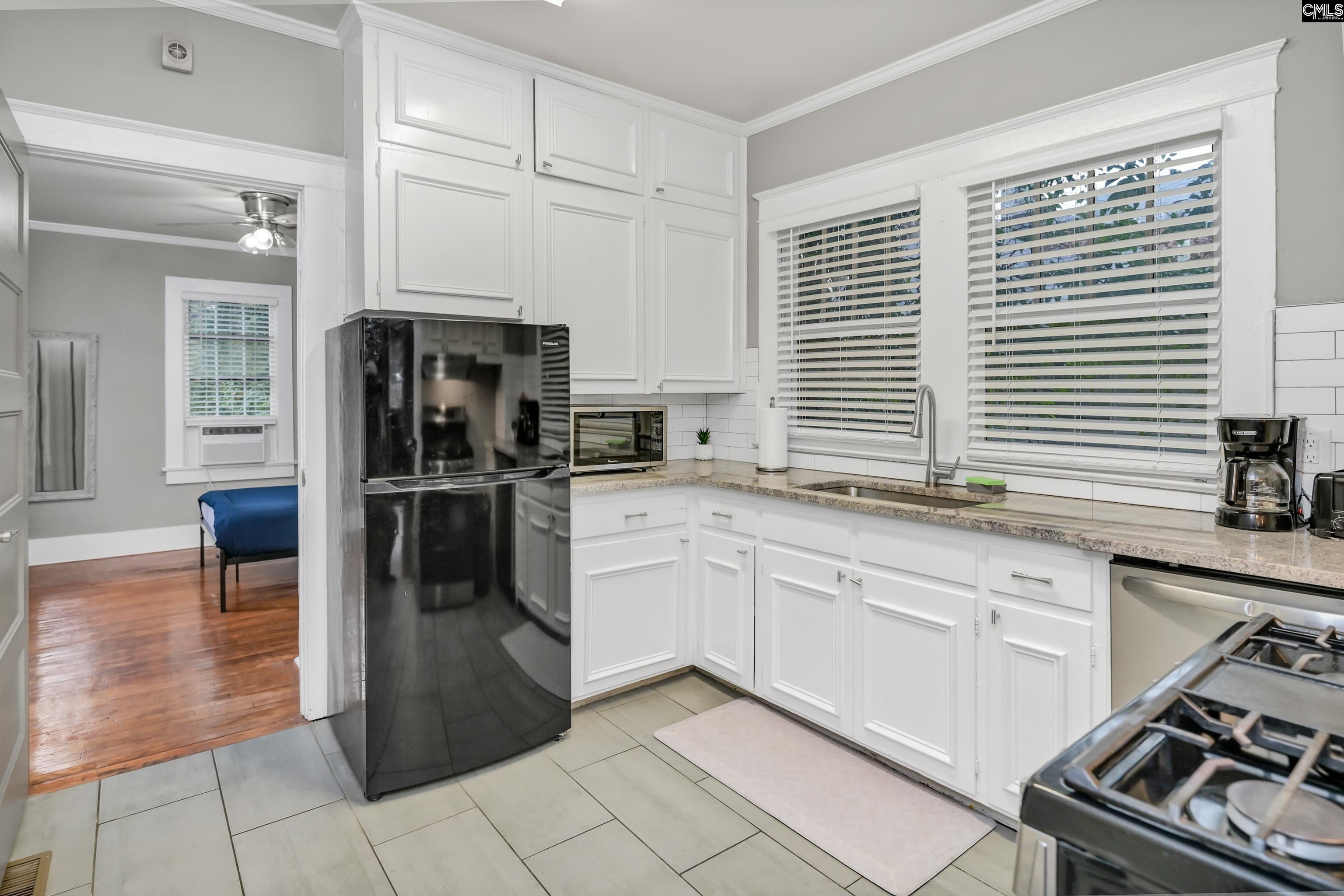 2227 Bull Street Columbia, SC 29201 - Photo 13 of 38 a kitchen with a sink a refrigerator and cabinets