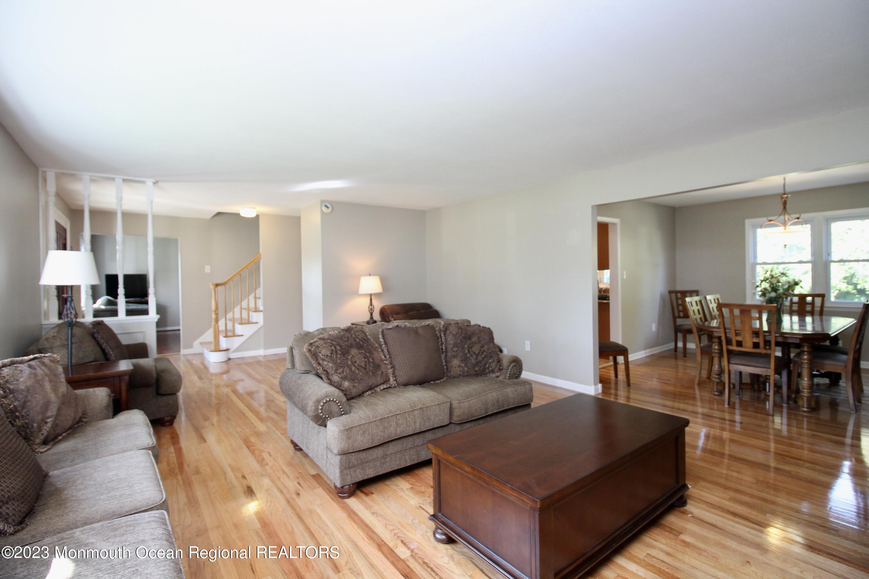 259 Kings Mountain Road Freehold, NJ 07728 - Photo 12 of 61 a living room with furniture and a dining table with wooden floor