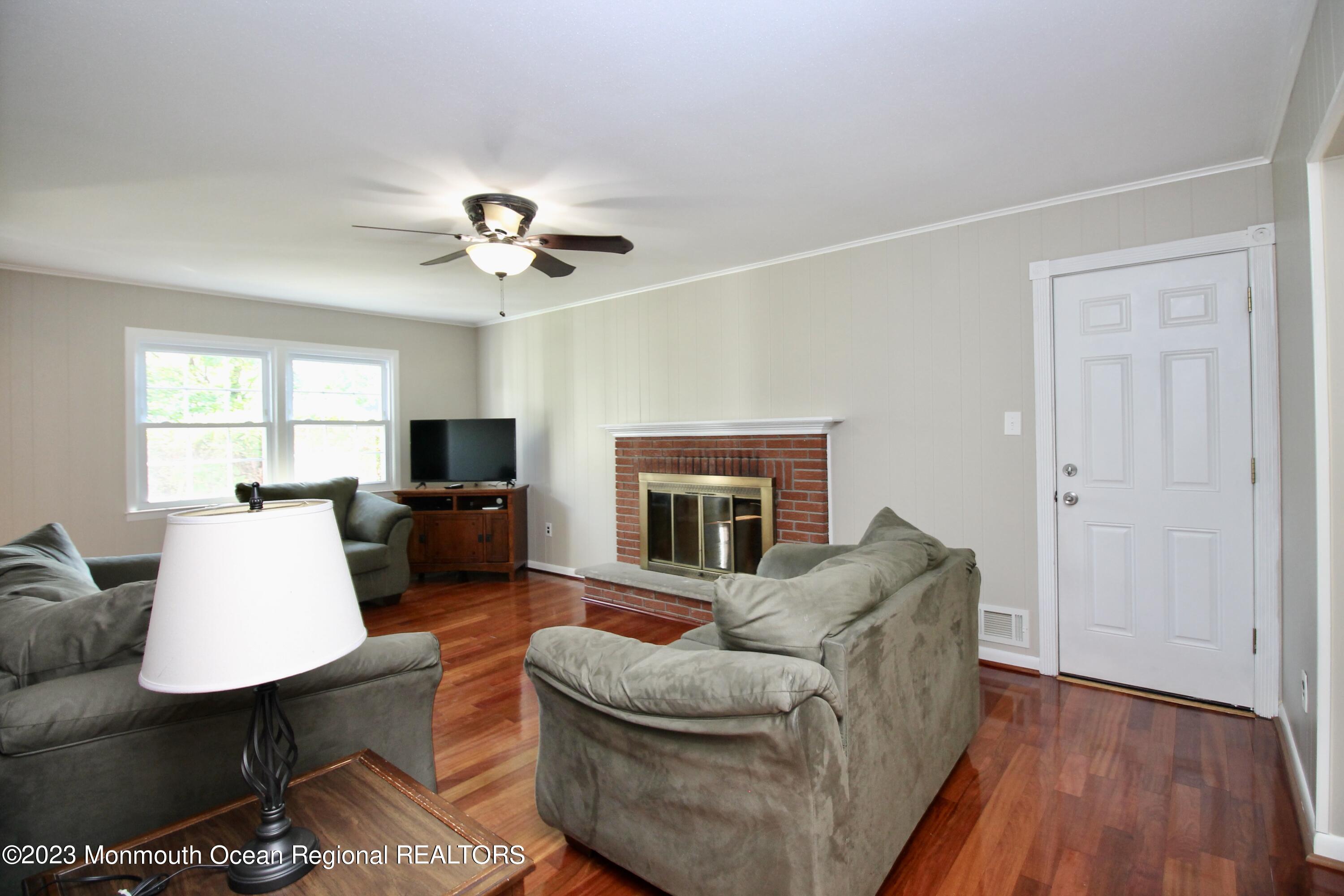 259 Kings Mountain Road Freehold, NJ 07728 - Photo 24 of 61 a living room with furniture a fireplace and a table
