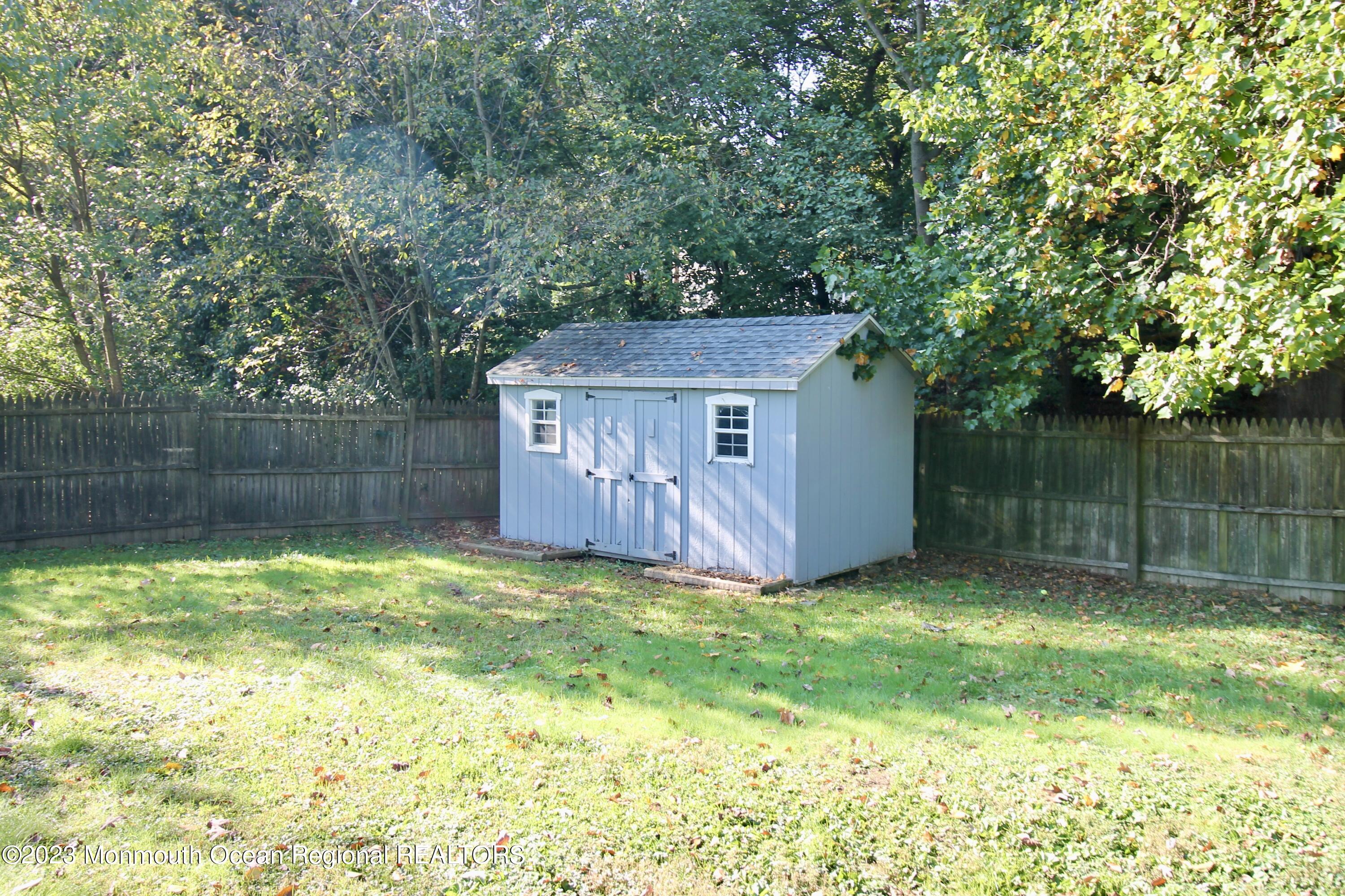 259 Kings Mountain Road Freehold, NJ 07728 - Photo 60 of 61 a view of a backyard with a small cabin and a chair