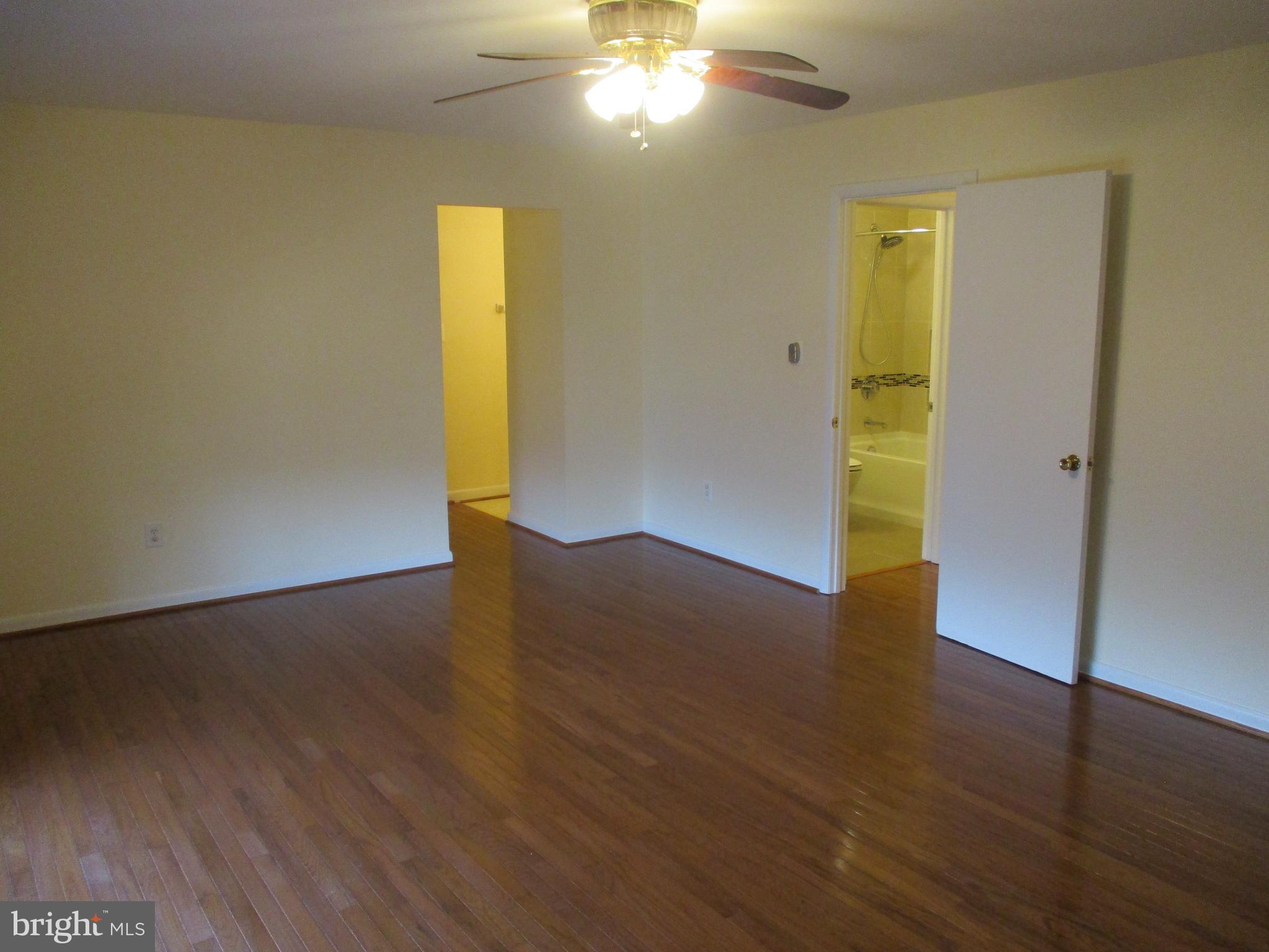 10357 Barcan Circle Columbia, MD 21044 - Photo 13 of 24 a view of empty room with wooden floor and fan