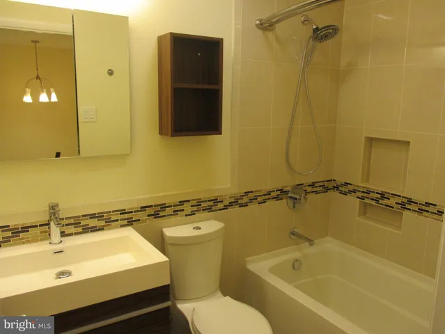 a bathroom with a sink mirror toilet and bathtub