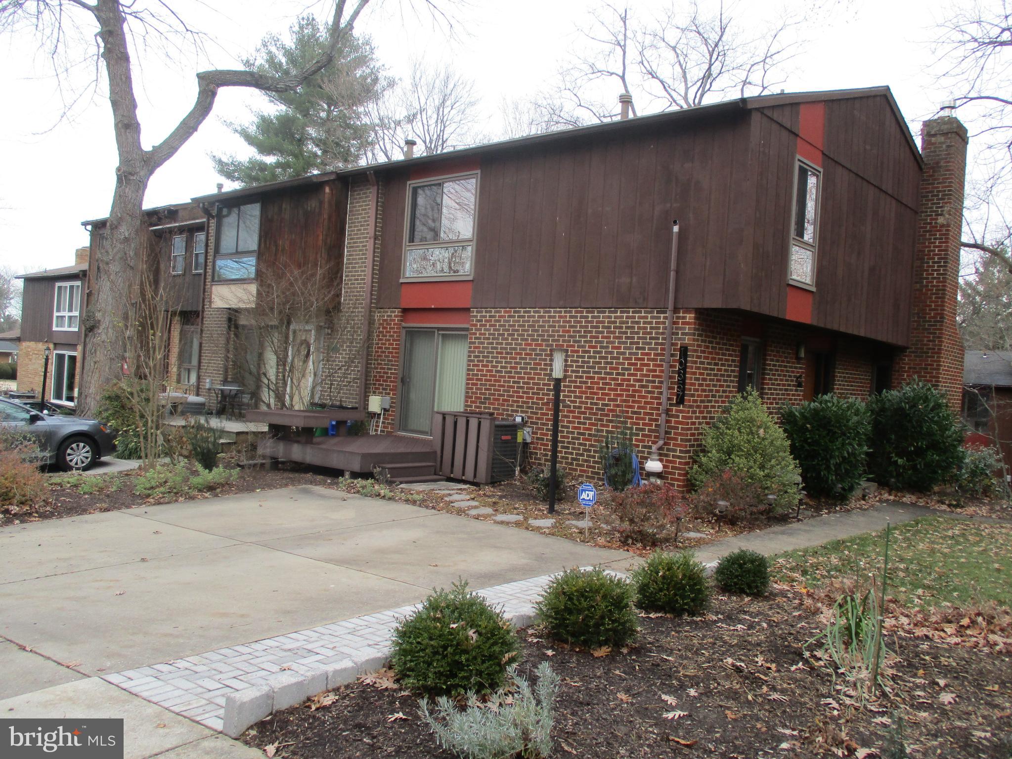 10357 Barcan Circle Columbia, MD 21044 - Photo 2 of 24 a street view with wooden fence and a car parked in front of house
