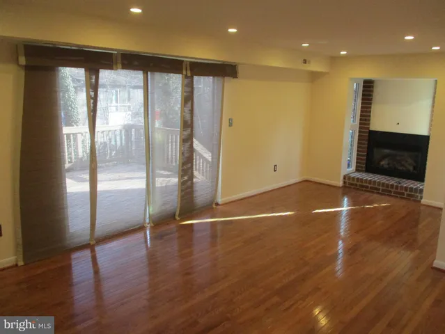 a view of empty room with wooden floor and fireplace