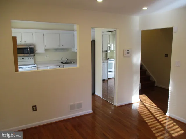a view of a kitchen with wooden floor and electronic appliances