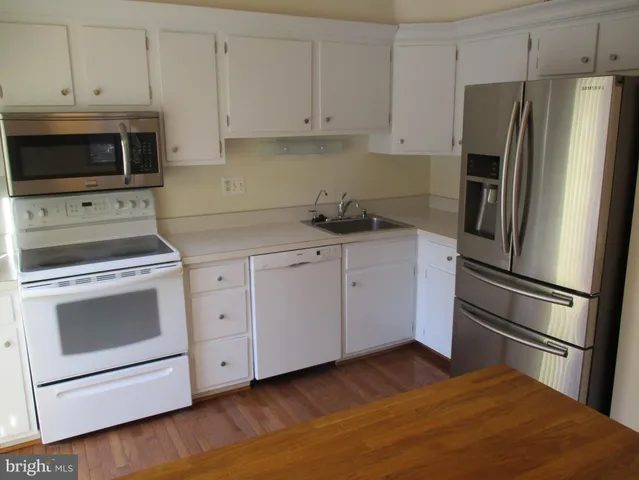 a kitchen with white cabinets stainless steel appliances and sink