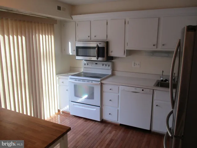 a kitchen with white cabinets stainless steel appliances and sink