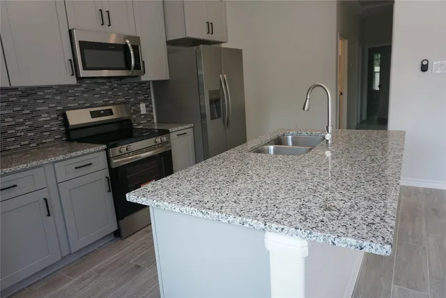 a bathroom with a granite countertop toilet a sink and bathtub