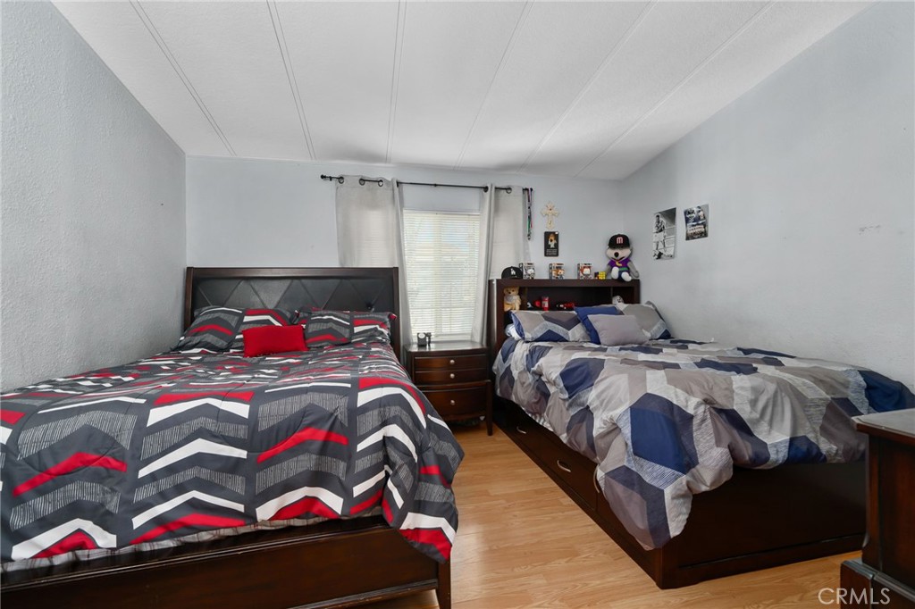 80 East Dawes, Unit 52 Perris, CA 92571 - Photo 11 of 21 a bedroom with two beds and a chandelier