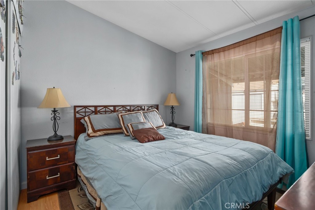 80 East Dawes, Unit 52 Perris, CA 92571 - Photo 17 of 21 a bedroom with a bed and a lamp on dresser