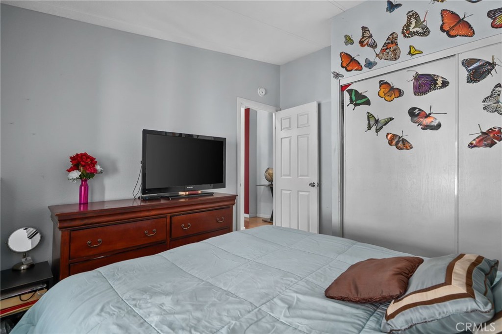 80 East Dawes, Unit 52 Perris, CA 92571 - Photo 18 of 21 a bedroom with a bed and a flat screen tv on dresser