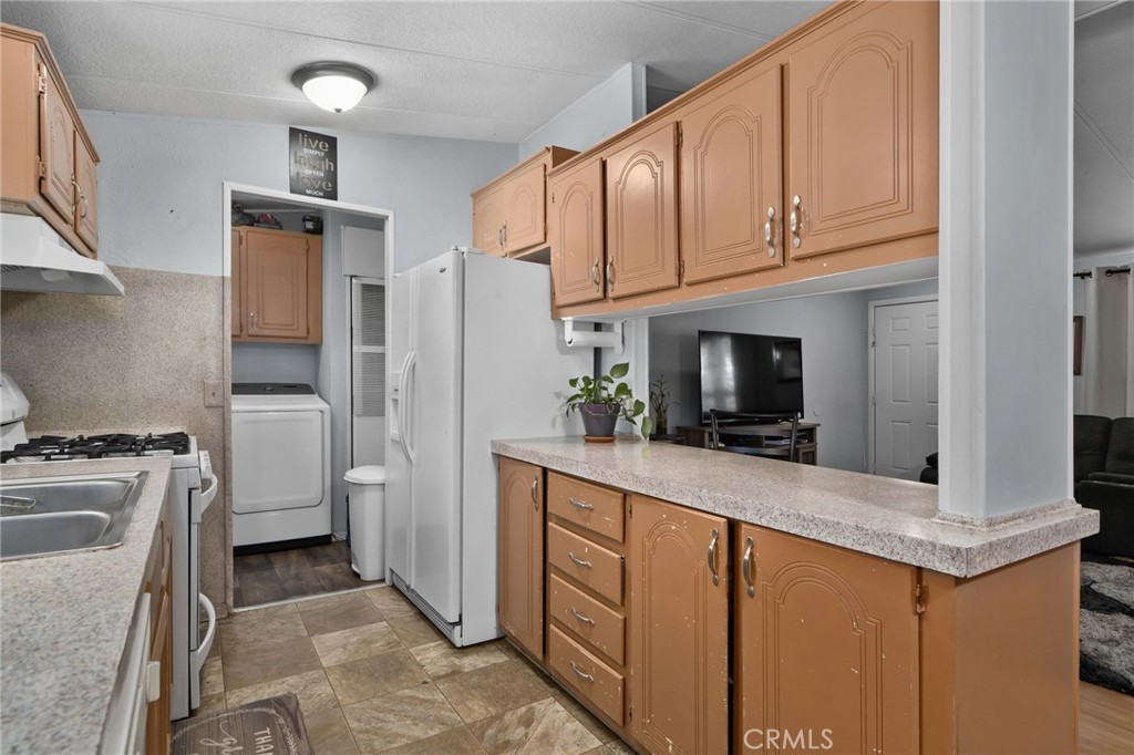 80 East Dawes, Unit 52 Perris, CA 92571 - Photo 8 of 21 a kitchen with stainless steel appliances granite countertop a refrigerator a stove and a sink