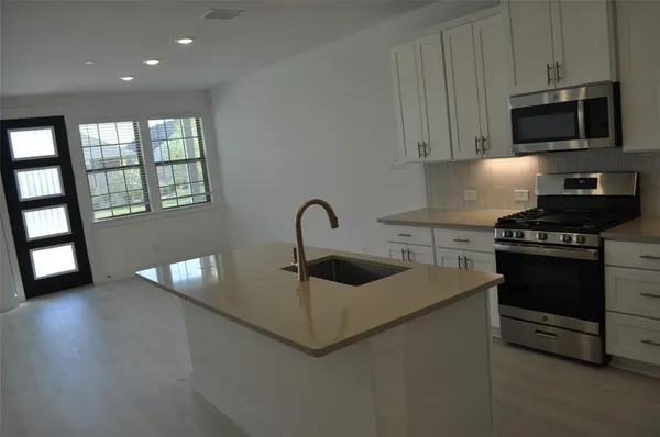 a kitchen with granite countertop a sink and a stove top oven