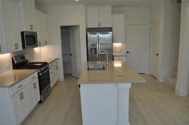 a kitchen with cabinets and stainless steel appliances