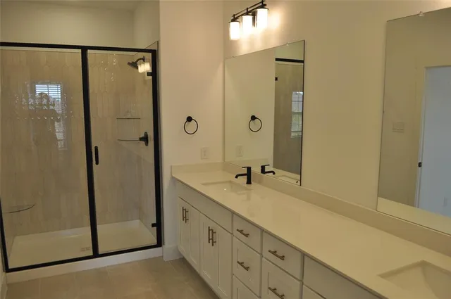a bathroom with a granite countertop sink mirror and shower