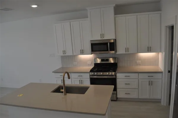 a kitchen with granite countertop a stove and a sink