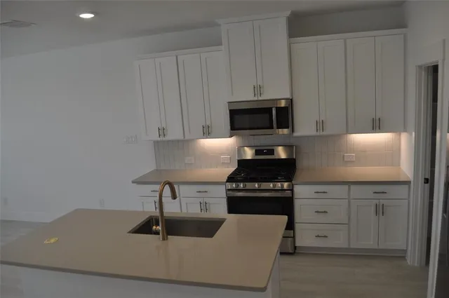 a kitchen with granite countertop a stove and a sink