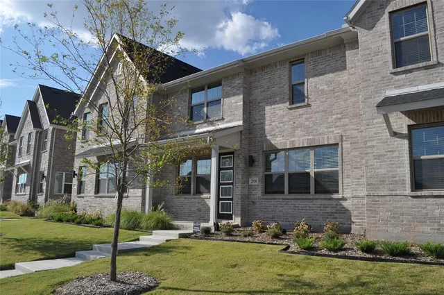 a view of a brick house with a yard