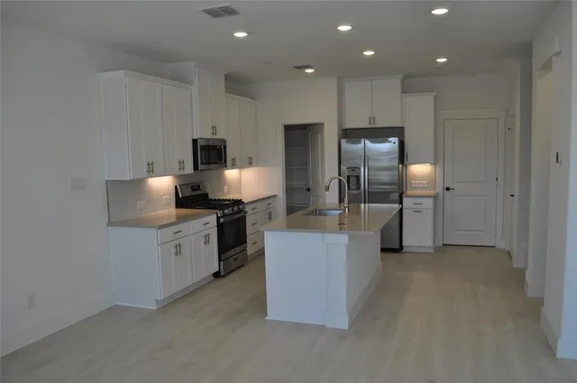 a kitchen with granite countertop cabinets and stainless steel appliances