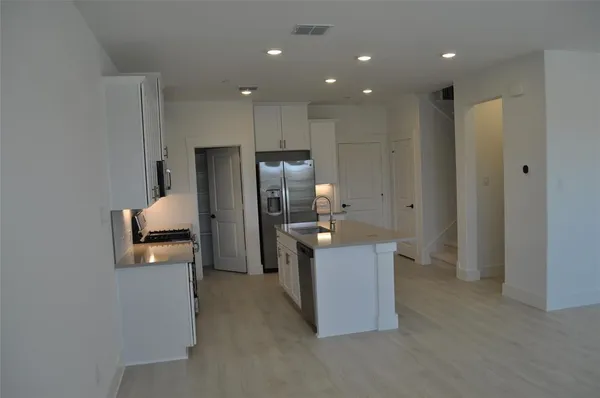 a kitchen with stainless steel appliances granite countertop a refrigerator and a sink