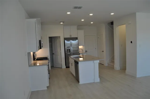 a kitchen with stainless steel appliances granite countertop a refrigerator and a sink