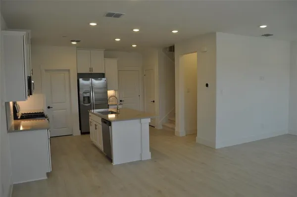a kitchen with kitchen island a counter top space cabinets and stainless steel appliances
