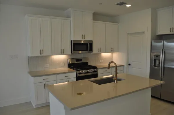 a kitchen with appliances a sink and a stove