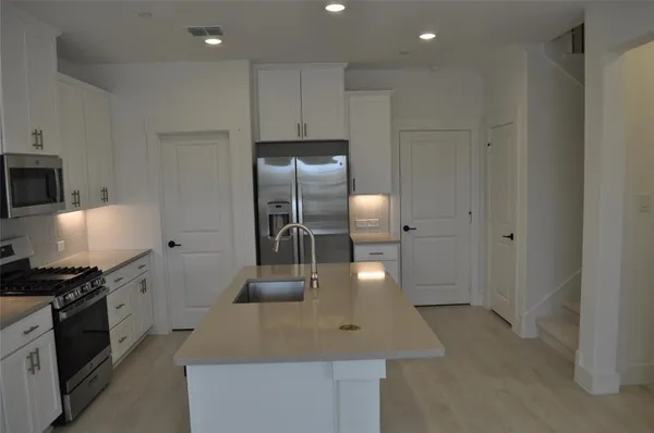 a kitchen with stainless steel appliances granite countertop a sink a stove and a refrigerator