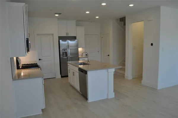 a kitchen with stainless steel appliances granite countertop a refrigerator and a stove