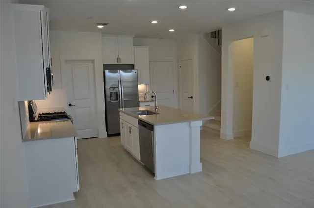 a kitchen with stainless steel appliances granite countertop a refrigerator and a stove
