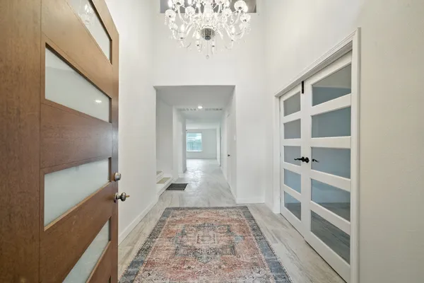 a view of a hallway with wooden floor and staircase