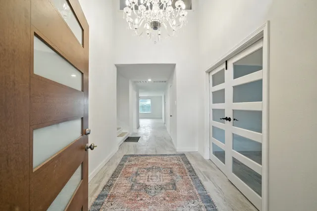a view of a hallway with wooden floor and staircase