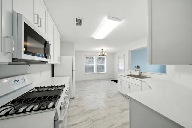 a kitchen with a stove a sink and a microwave