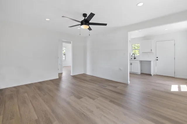 a view of a livingroom with wooden floor and a ceiling fan